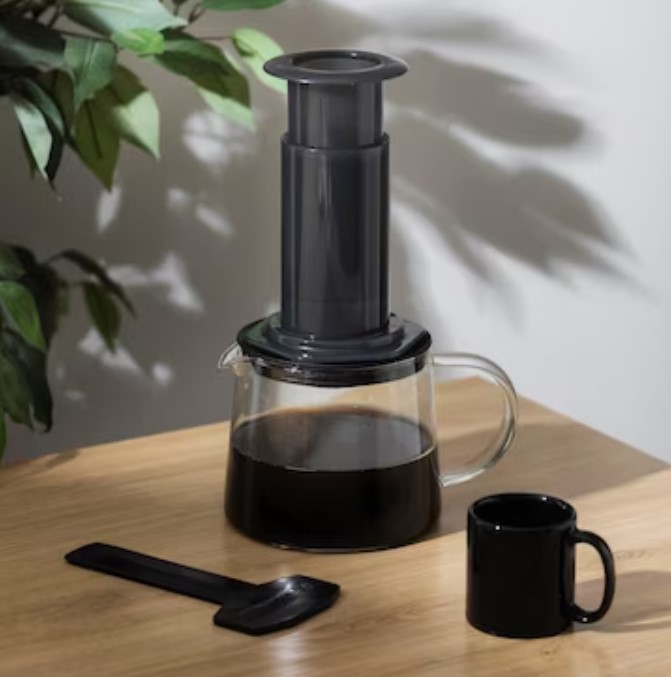 an aeropress hand brew with a cup of coffee