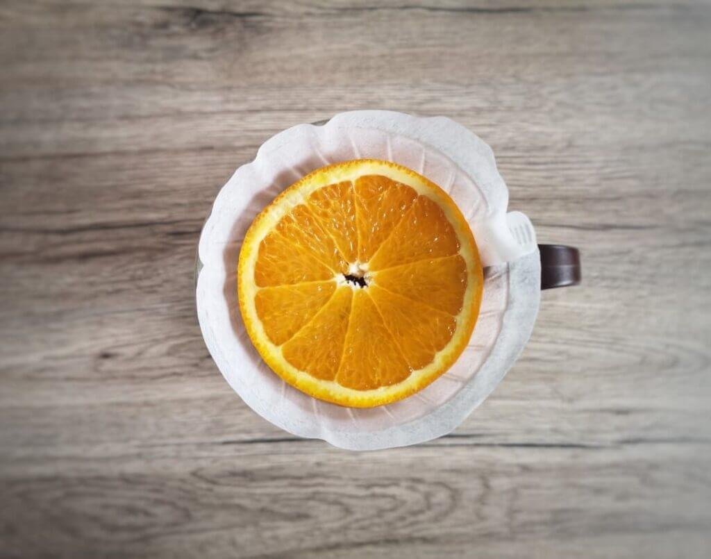making coffee with a v60 coffee maker and using orange slices